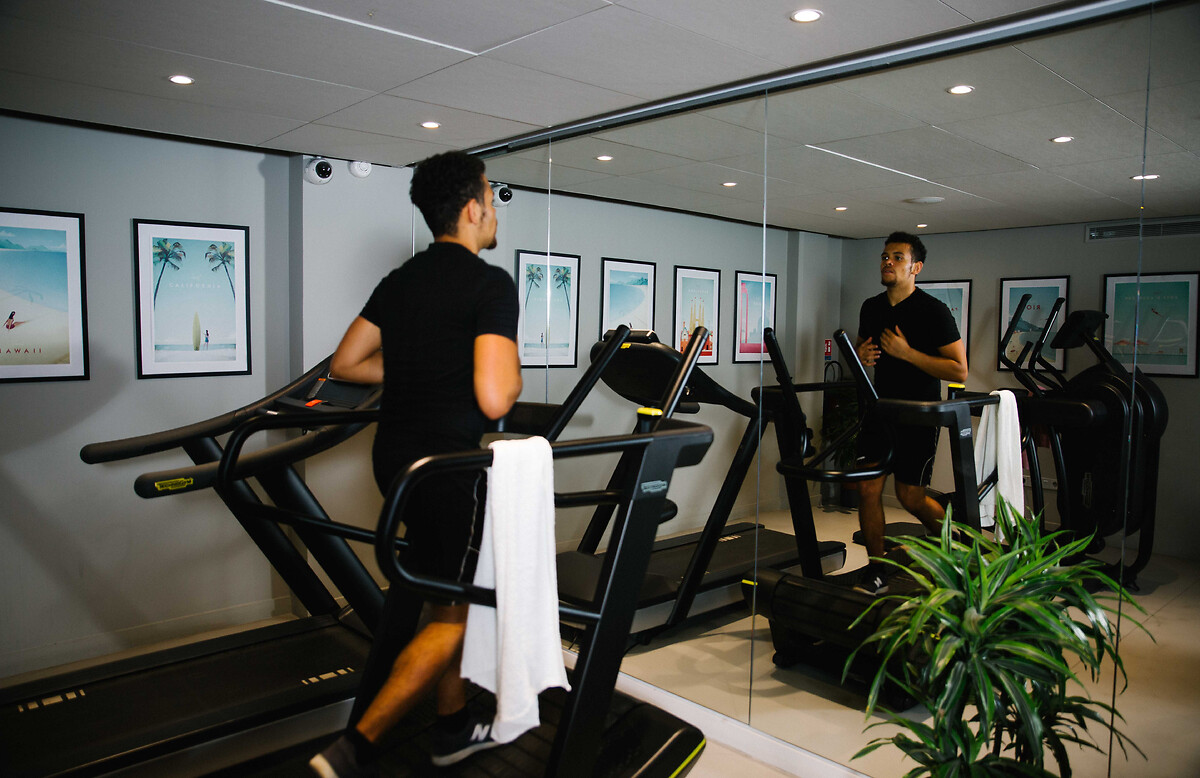 Etudiant qui fait du sport dans la salle de fitness: résidence étudiante Paris La Défense 