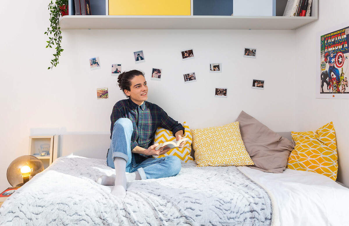 Etudiante et jeune actif lisant un livre dans son logement pour étudiants et jeunes actifs à Paris La Défense Grande Arche