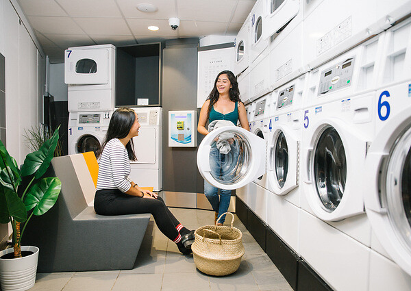 Deux étudiantes ou jeunes actives dans la laverie d'une résidence étudiante et jeune actif YouFirst Campus